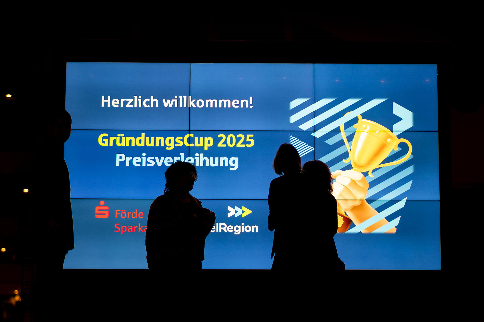 Schatten von Menschen vor einer Präsentationswand
