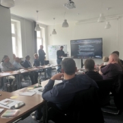 Das Foto zeigt einen Konferenzraum, auf dem mehrere Workshopteilnehmer zu sehen sind, die nach vorne zum Referenten blicken.